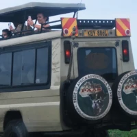 Tourist with Pride of Africa adventures and safari vehicle a top tours and travel agencies in Kenya